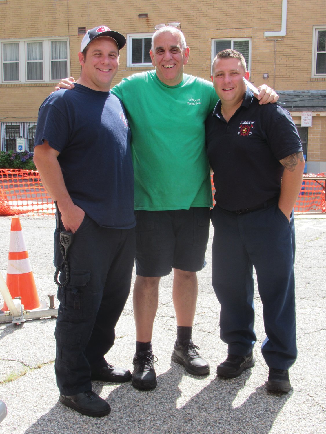 SPECIAL STAFF: Saint Rocco’s Co-Chairman Richard is joined by Johnston Firefighters Mark Livingston (left) and Anthon Colella II who were on duty Sunday in case of an emergency.